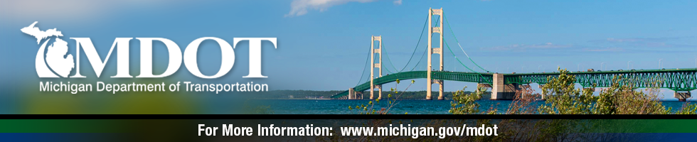 The Mackinac Bridge on a sunny day with blue skies and trees in the forefront with the MDOT logo and the MDOT webpage address.