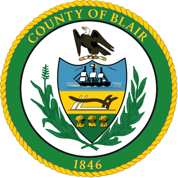Seal of Blair County featuring an eagle, ships, and a landscape, surrounded by a green border with 
