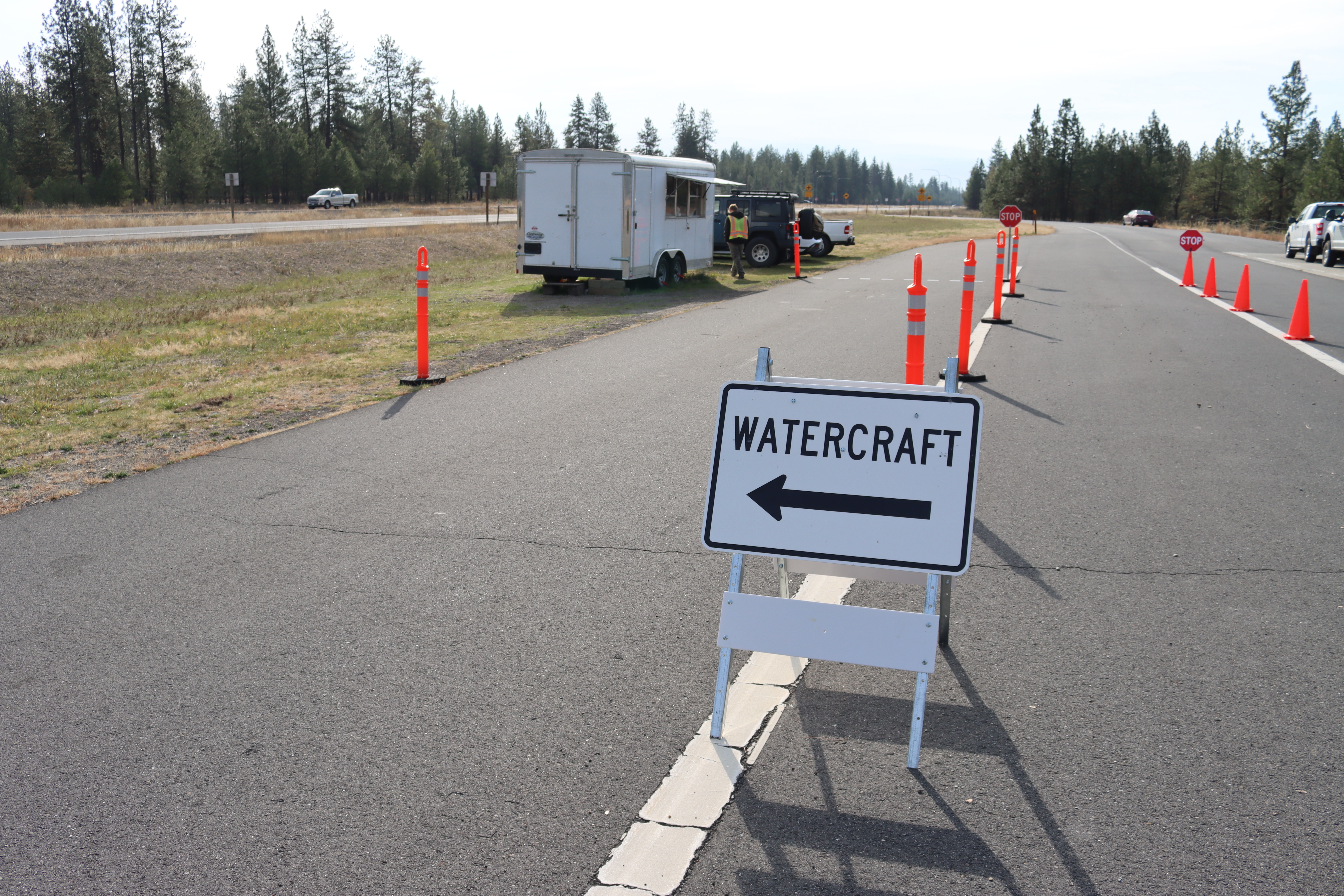 View of a watercraft inspection site with traffic cones to direct vehicles.
